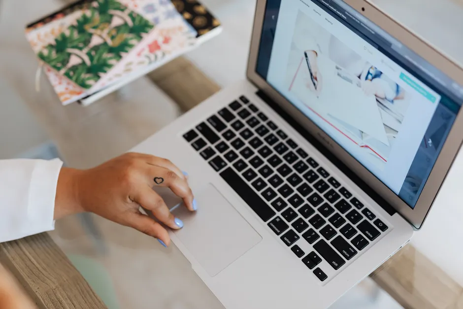 Close-up of a person using a laptop at a desk, focusing on technology and efficiency.