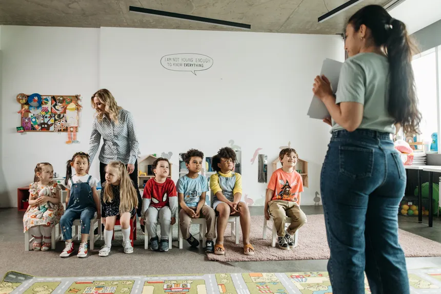 Diverse group of preschool children and teachers in an engaging classroom setting.